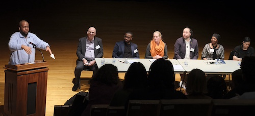 José Vilson and a panel of speakers on stage
