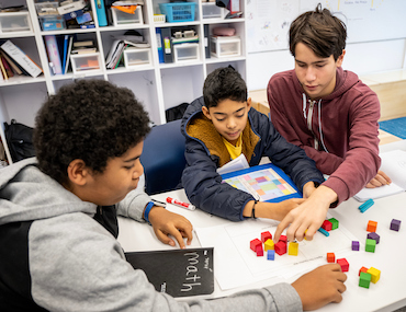 Three students working on math problem