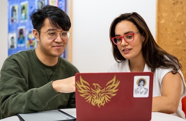 Two adults looking at a laptop