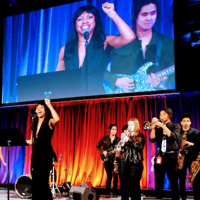 Vocalist Sasha Allen performs on stage with NYC public school students