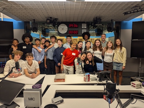 Eighth grade students posing for a group photo inside an NPR studio