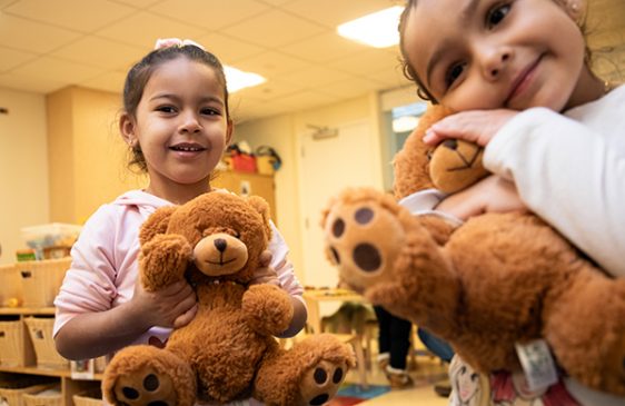 Two children hug teddy bears
