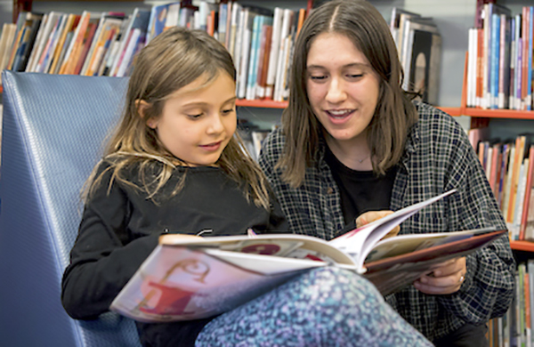 Student teacher working with a student in the library at Bank Street