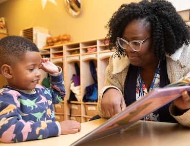 Young student and educator reading together in a classroom