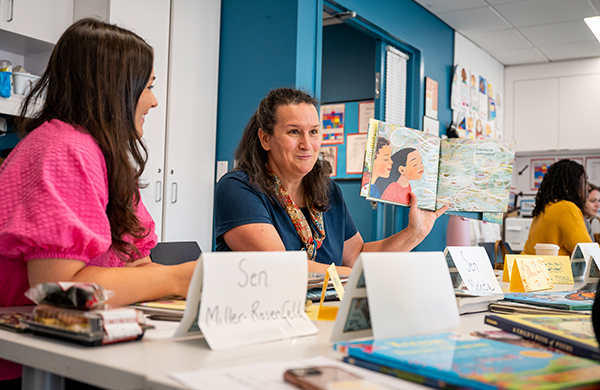 Literacy class with grad students listening to an instructor seated at a table