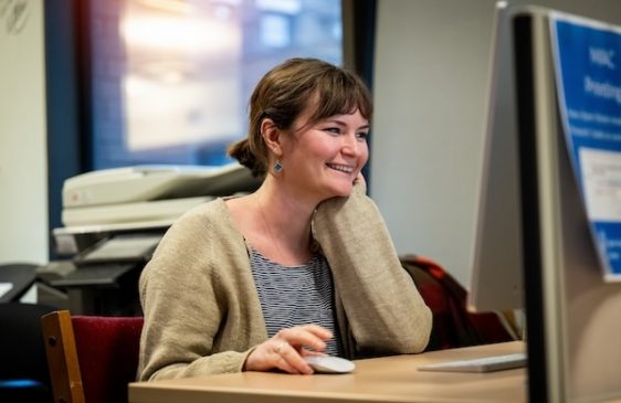 Grad student at computer smiling