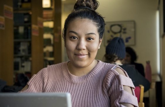 Grad student on laptop smiling
