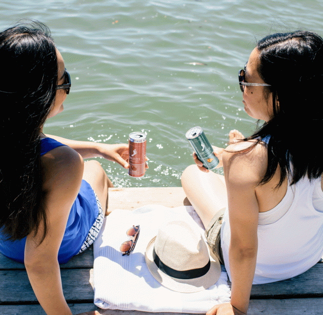 Two women on a dock with cans