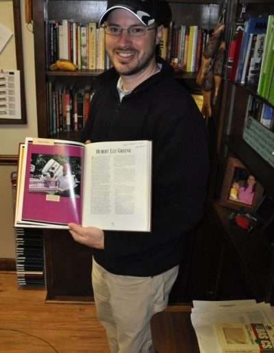 2014. Andy Greene posing with the Living Legends book, opened to his Dad's page. Photo Terry Battisti.
