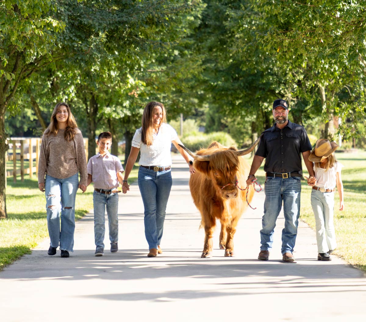 Rohloff family and a cow walking down their ranch's lane