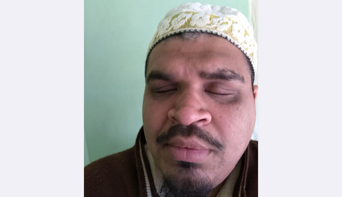 A profile picture of Dr. Yusuf. He’s wearing a white hat with golden embroidery and a dark, red sweater.