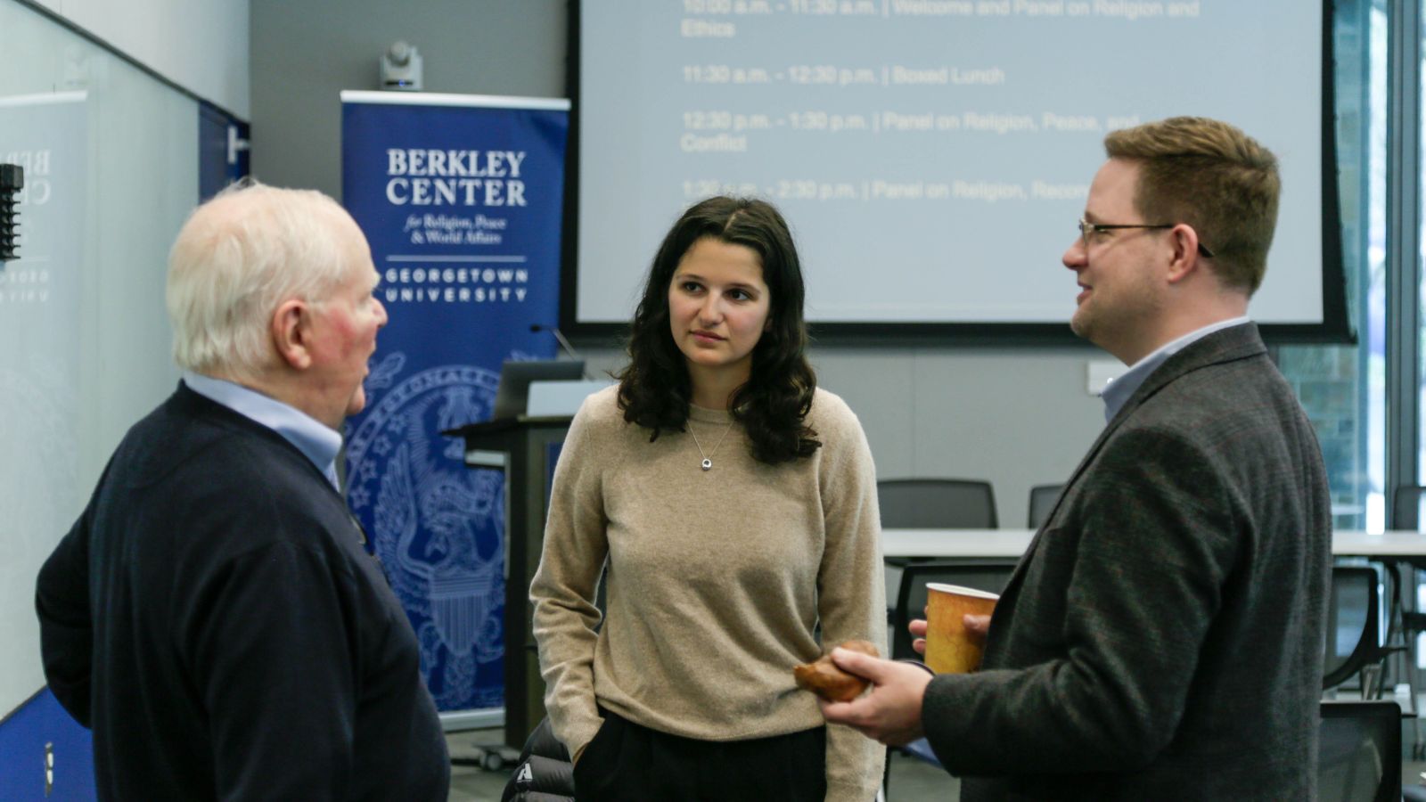 Conference participants engage in dialogue during lunch break.
