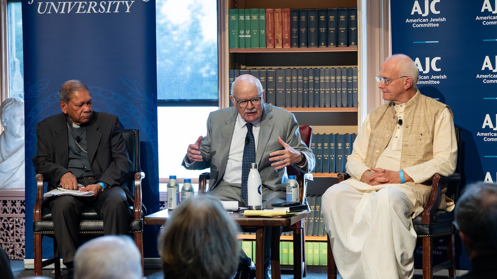 Archbishop Felix Machado, John Borelli, and Sriman Anuttama Dasa speak at a panel during the conference.