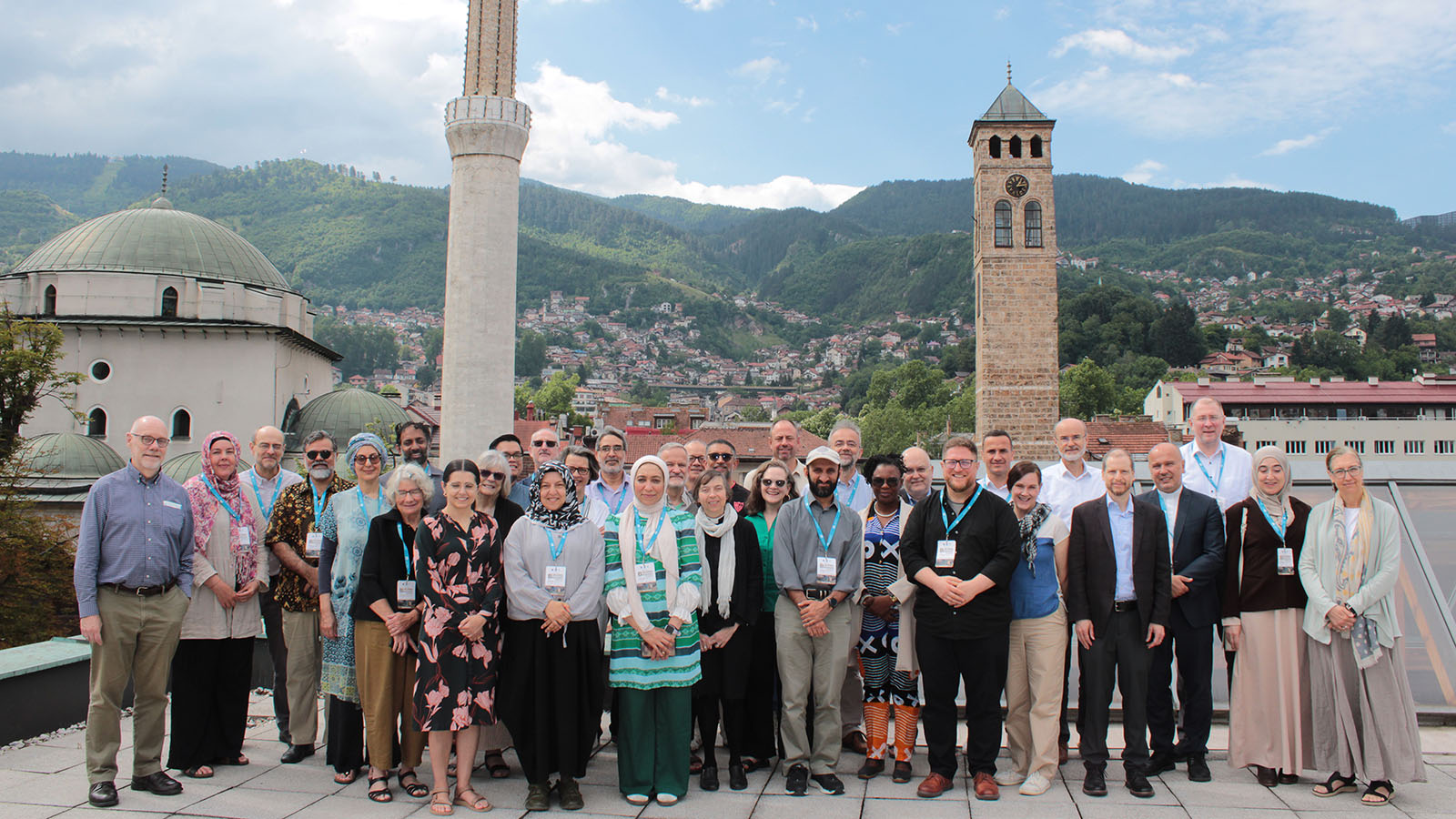 Group photo of Building Bridges Seminar participants with a mosque and cityscape in the background