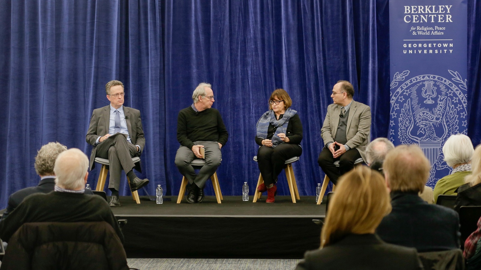 Panelists speak on the stage at the February 2026 Democracy and the Culture of Encounter event