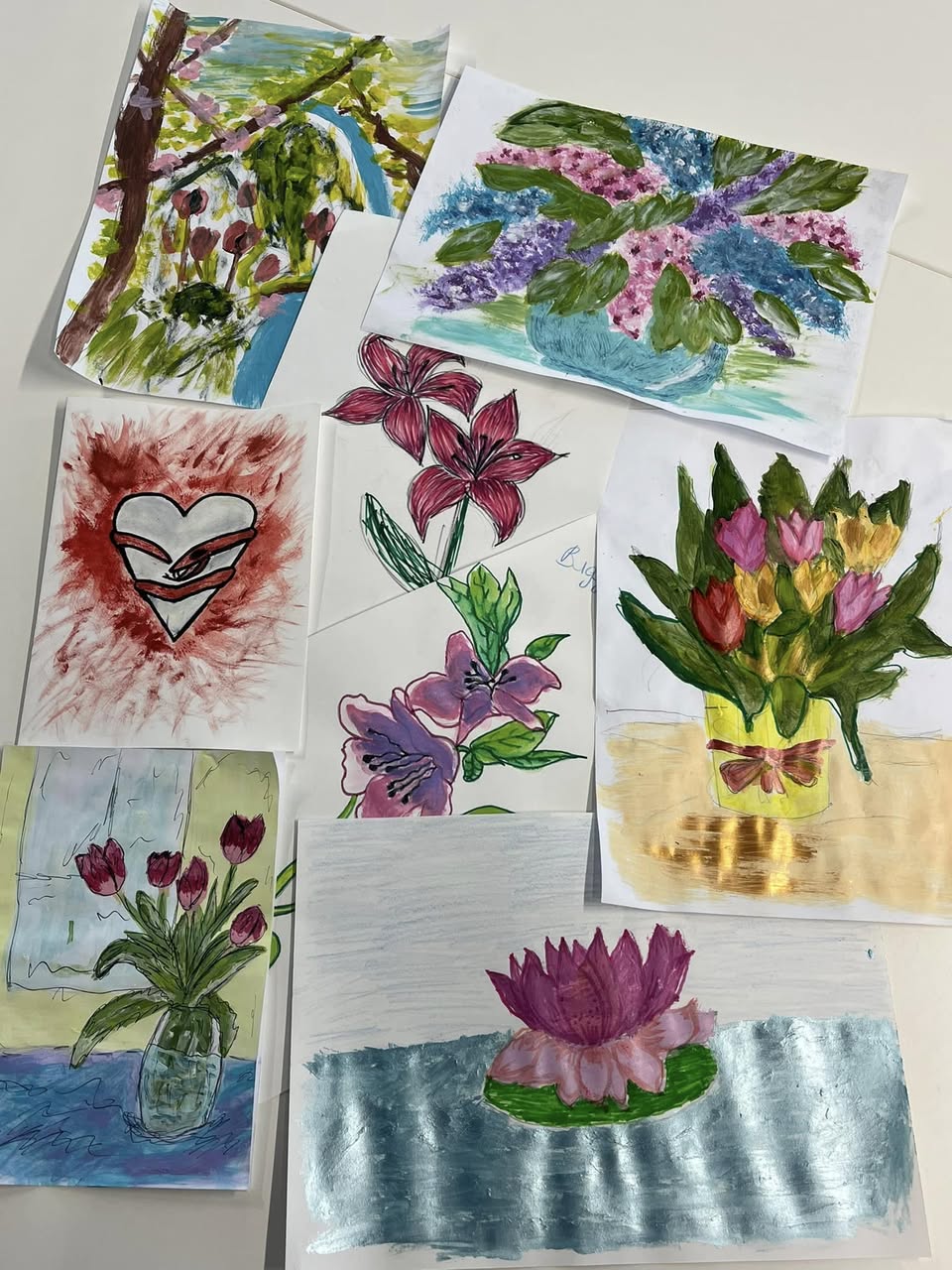Artwork of flowers and a heart displayed on a white table