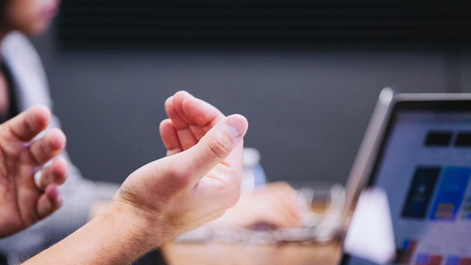 A person presenting at a meeting with their laptop