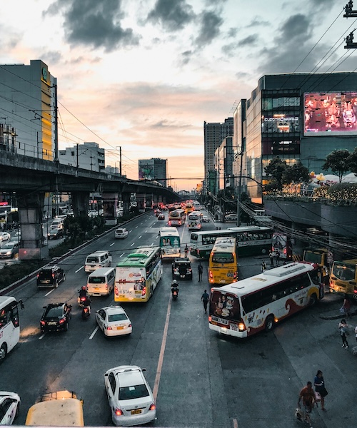 Cars and buses driving down a street in the Philippines