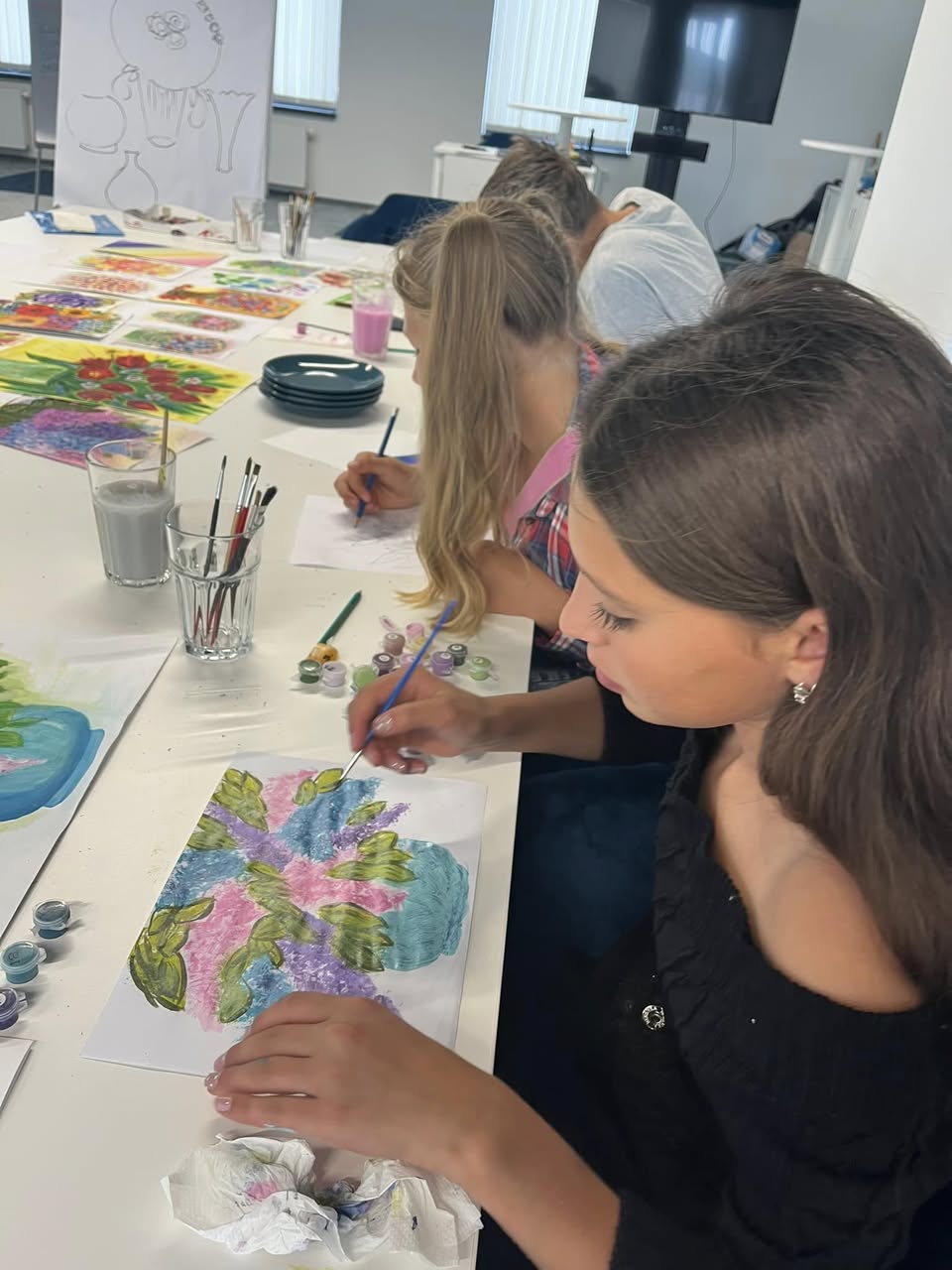 Students painting at a white table