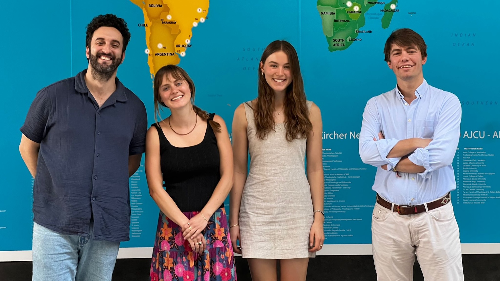 Students and staff standing in front of a world map