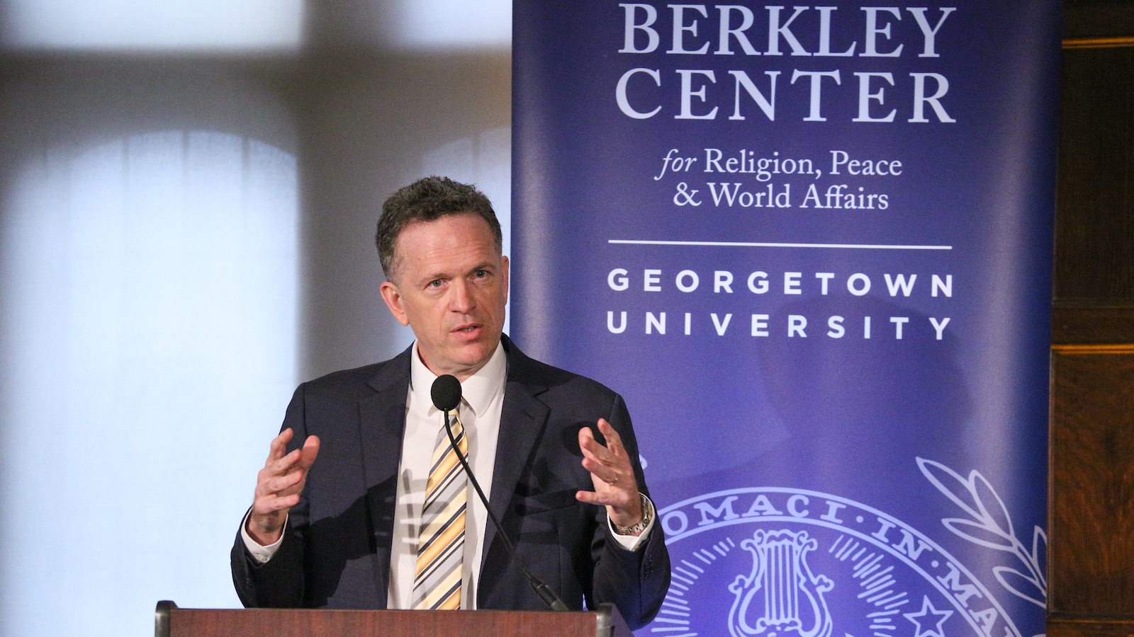 Thomas Banchoff speaking at a podium.