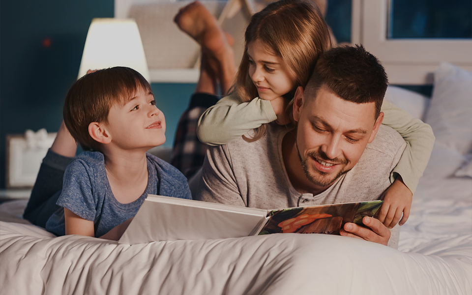 Pai lendo para os filhos na hora de dormir