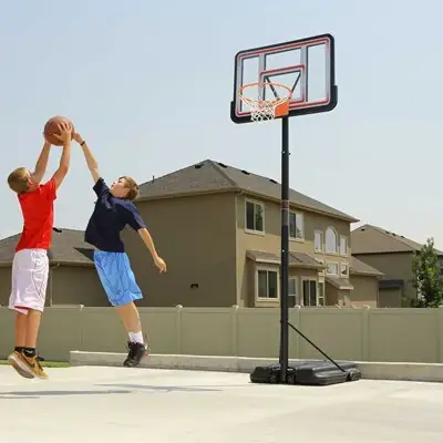 boys play youth basketball at home with a basketball hoop in the yard