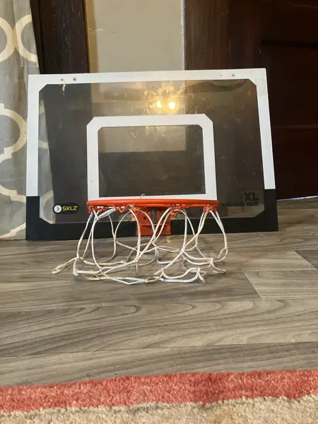 A children's basketball hoop and net are displayed on the floor for reference.