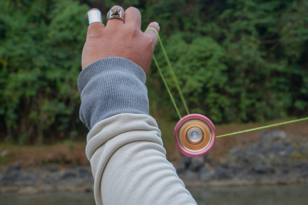 The hand figure of a man playing a yoyo by using basic yoyo tricks for beginners