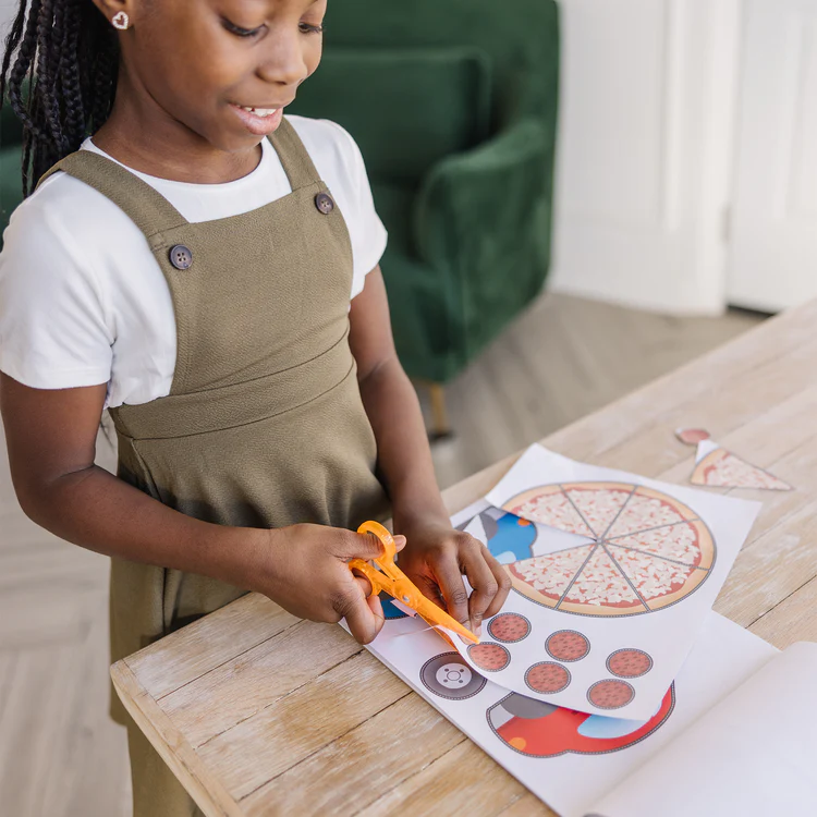 A girl uses measuring toys for preschoolers to cut out sized paper patterns.