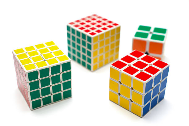 Different versions of the Rubik's Cube, shown isolated on a white background. The Rubik's Cube is a 3D mechanical puzzle that utilizes the PLL Parity 4x4 algorithm to solve the alignment problem.