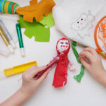 Little girls sew dolls and doll clothes in the classroom, making sewing accessories and using doll making supplies.