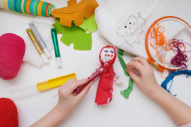 Little girls sew dolls and doll clothes in the classroom, making sewing accessories and using doll making supplies.