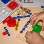 A child is assembling stem toys for 8-year-olds on a table