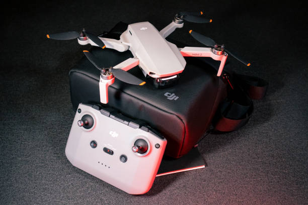 DJI Mavic Mini 2 4K video camera drone, a quadcopter, with remote controller, under red lighting.