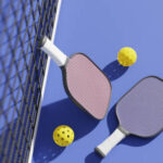 Rackets And Balls For Playing Pickleball At The Sports Net On The Court,also Fall Under The Category Of Sports Ball Sets