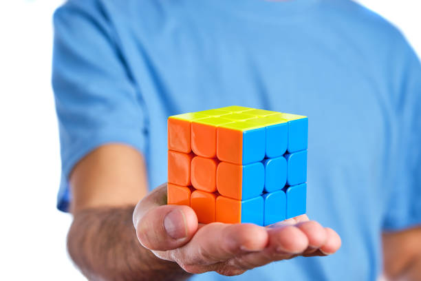 A Man Holding A Solved Rubik's Cube From A Magic Cube Competition