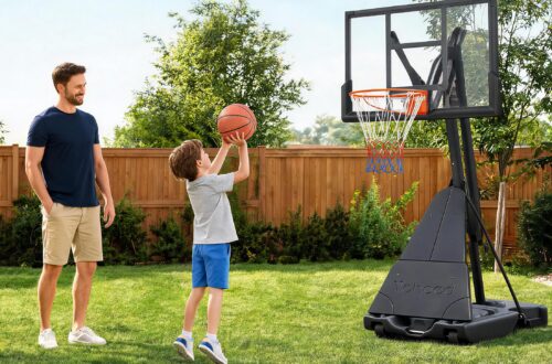 A cheerful father watching his young son practice a shot on a heavy-duty Yohood basketball goal with a foldable side frame system in a sunny backyard.