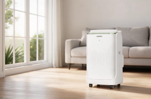 Sleek white ZAFRO smart inverter portable air conditioner standing on a hardwood floor in a minimalist sunlit modern living room.