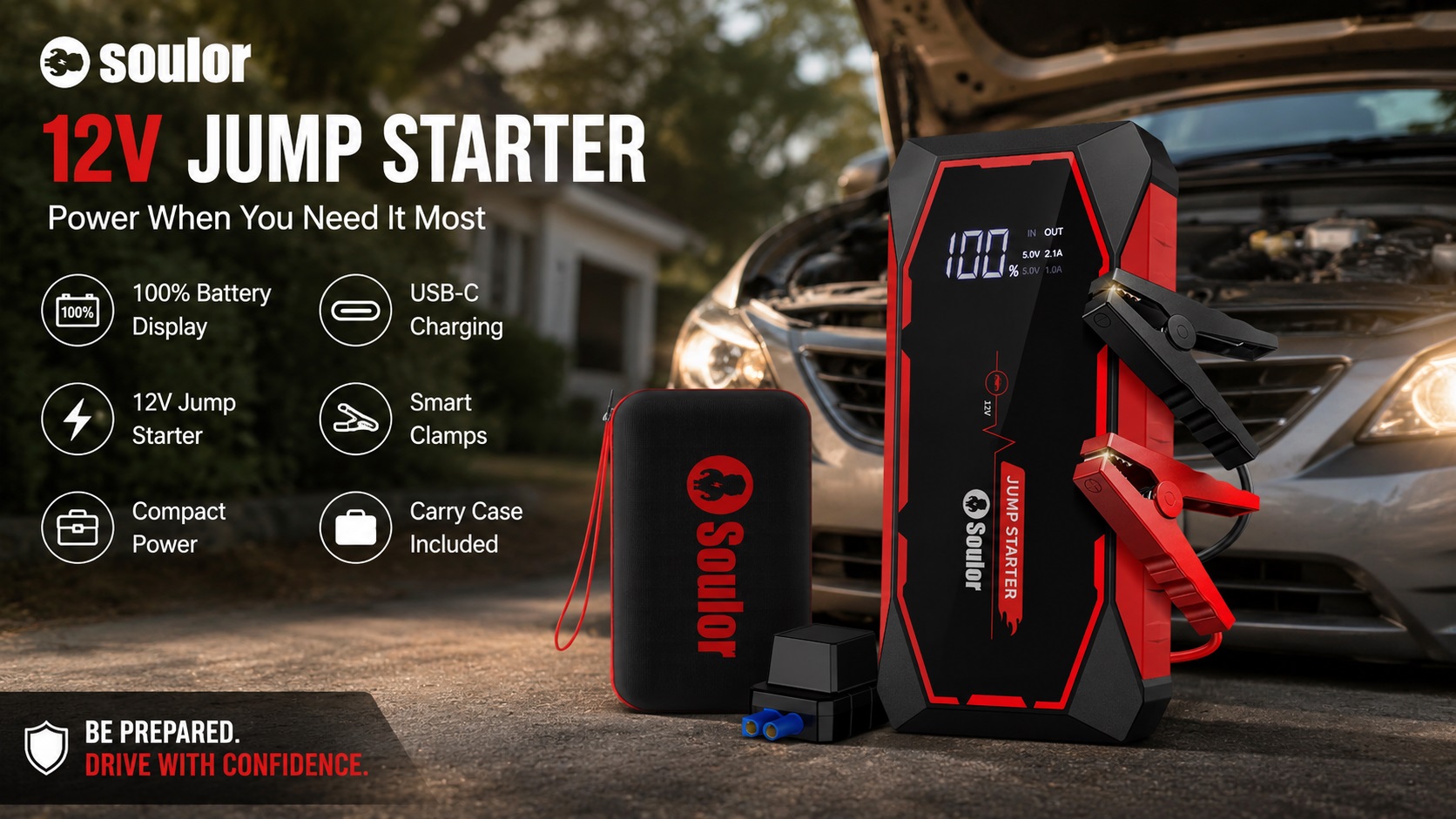 Soulor 12V portable car jump starter with 100% digital battery display resting on the ground in front of a car with smart clamps and carrying case.