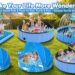 A comprehensive collection display of premium splash pads and foldable family pools on a sunny green lawn. Features include square fountains, round sprinkler pools, infant canopy pools, and a giant dog pool with a family playing together.