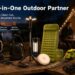 An OGERY Brand Overview image featuring a group of people at a lakeside campsite with various OGERY products spread out on a table: a tripod light, power station, portable fan, sleeping pad, grass shear, and string lights. Text reads "Your All-in-One Outdoor Partner" with brand values like Reliable Performance and Portable Design.