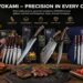 Comprehensive showcase banner of SYOKAMI knives and sets displayed on a rustic wooden table with cooked steak, fresh veggies, and a wooden knife block.