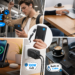 A montage of diverse lifestyle scenes showcasing different INIU charging products in use. Scenes include a man on public transit with a power bank, a laptop charging on a table with a 45W bank, a phone charging on a bedside 15W wireless stand, a 100W GaN charger powering multiple devices, and a laptop with a built-in cable bank at an outdoor cafe. Text reads: "Power Up Your Life" and "NO.1 Portable Charging Brand*."