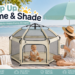 The California Beach Company Pop ’N Go playpen in warm ivory at a sunny beach, paired with a mint shade umbrella, baby and parent, highlighting portable, indoor-outdoor family use.