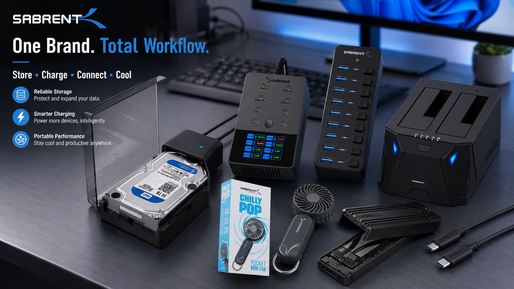 SABRENT technology product lineup displayed on a modern workstation, featuring storage devices, charging hubs, USB accessories, docking stations, portable fan, and SSD enclosure solutions.