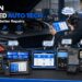 TOPDON automotive diagnostic tools displayed across a professional workshop bench with a technician scanning a vehicle, featuring BT600, AD800BT, ArtiDiag Pro, BT50, ArtiLink 400 and RLink J2534 solutions.