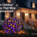 Halloween front-yard blog banner in blue-hour dusk, featuring YGTCHNG storefront holiday lights installed on a cozy suburban house porch โ a round shrub wrapped in purple-and-orange net lights, warm orange incandescent string lights draped along the eaves, glowing jack-o'-lanterns and bat silhouettes; bold English callouts with cute cartoon witch-hat, pumpkin and sparkle graphics overlaid.