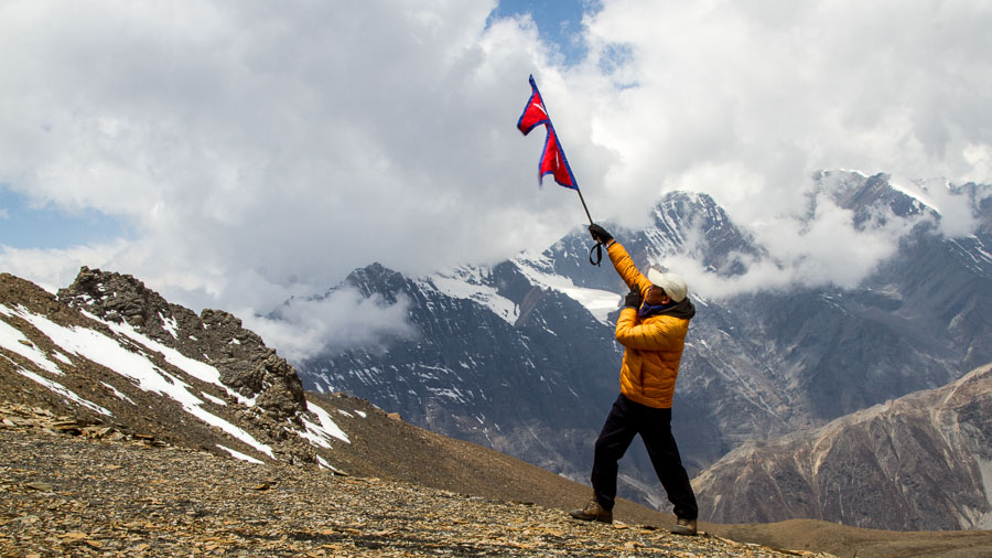 Tripple P Gurung raises the Nepali flag on top of the Naar Pass.