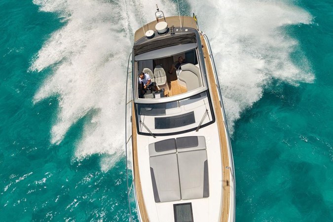 2018 Princess V40 yacht cruising on clear blue waters near a scenic coastline.